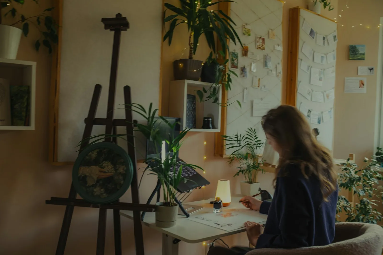 A designer working at a plant-filled desk in the Copenhagen studio