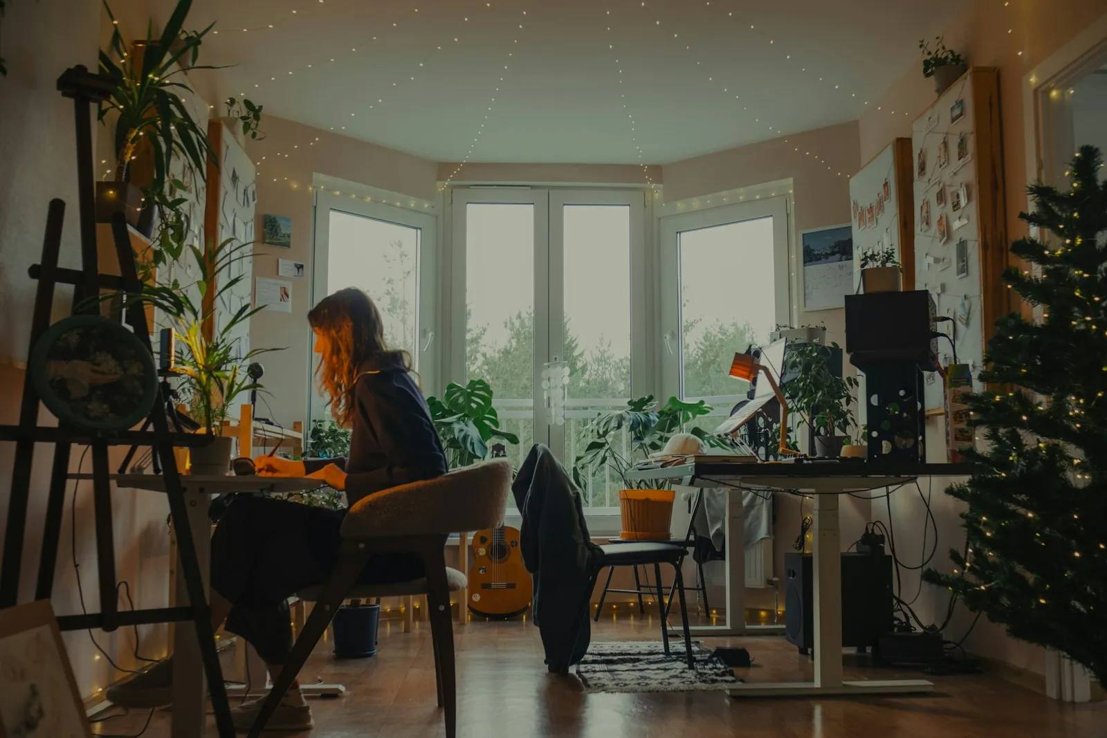 A sunlit corner of the Lumera studio with plants and a desk by the window